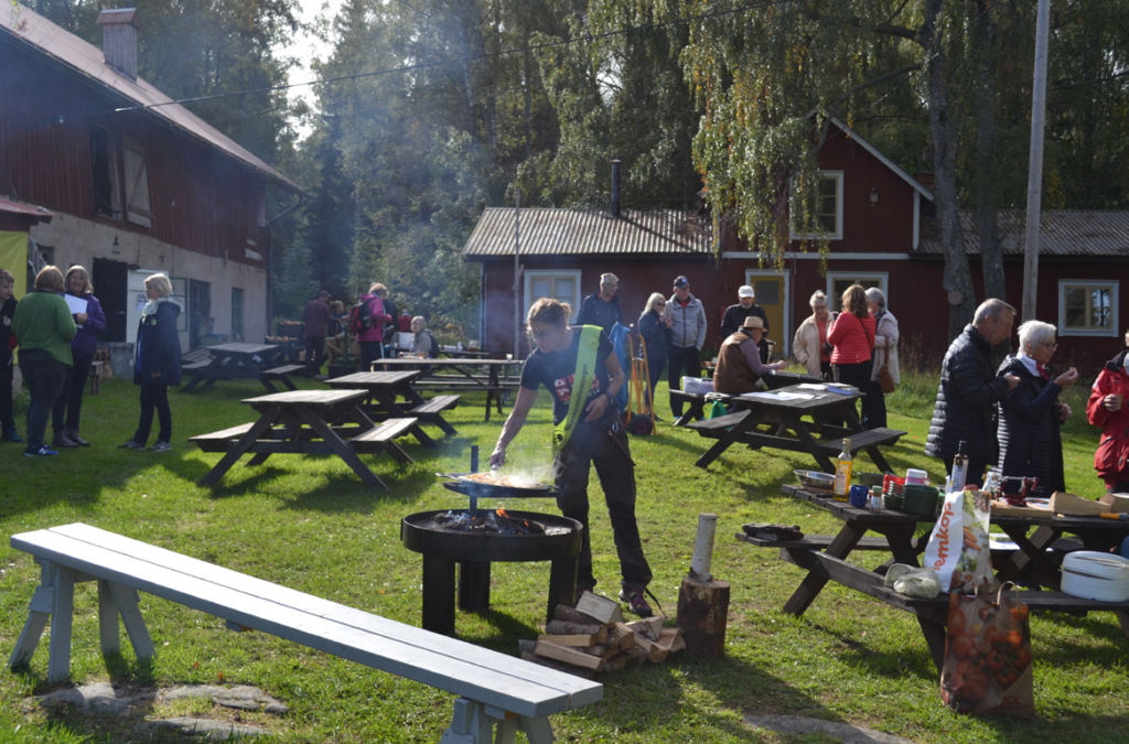 Människor som grillar och äter korv