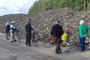 Cyklister vid en hög med industriavfall